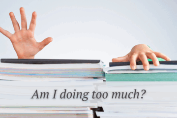 someone struggling behind a pile of papers and books and the words am I doing too much?